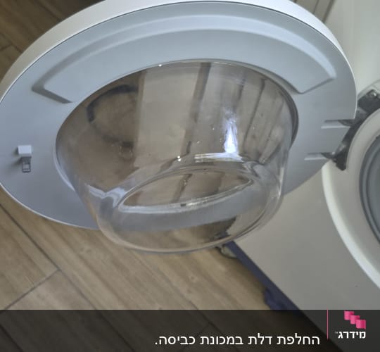 דלת מכונת כביסה פתוחה בחדר אמבטיה